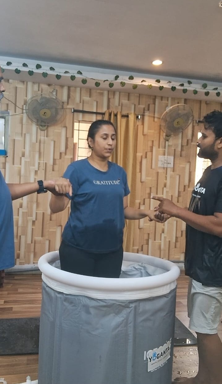 Dr. Vinayana Jain seated in the ice bath with her hands joined in front of her at the Yoganta Ice Bath Instructor Course (YCIBI) workshop in Hyderabad.