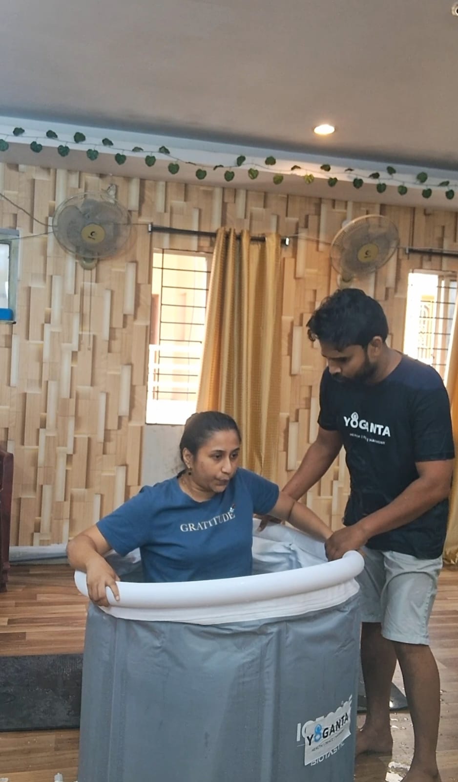 Dr. Vinayana Jain seated in a Yoganta ice bath tub with a trainer beside her at the Yoganta Ice Bath Instructor Course (YCIBI) workshop in Hyderabad.