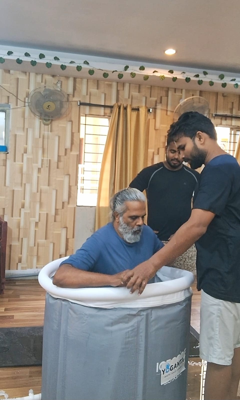 Hari Subramanyam seated in a Yoganta ice bath tub with trainers standing beside him at the Yoganta Ice Bath Instructor Course (YCIBI) workshop in Hyderabad.