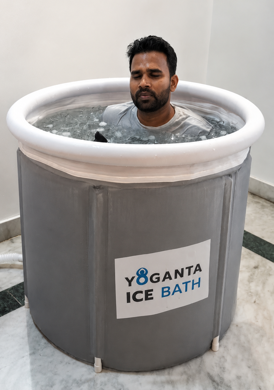 Raushan Yoganta sitting in a grey Yoganta Ice Bath tub filled with icy water.
