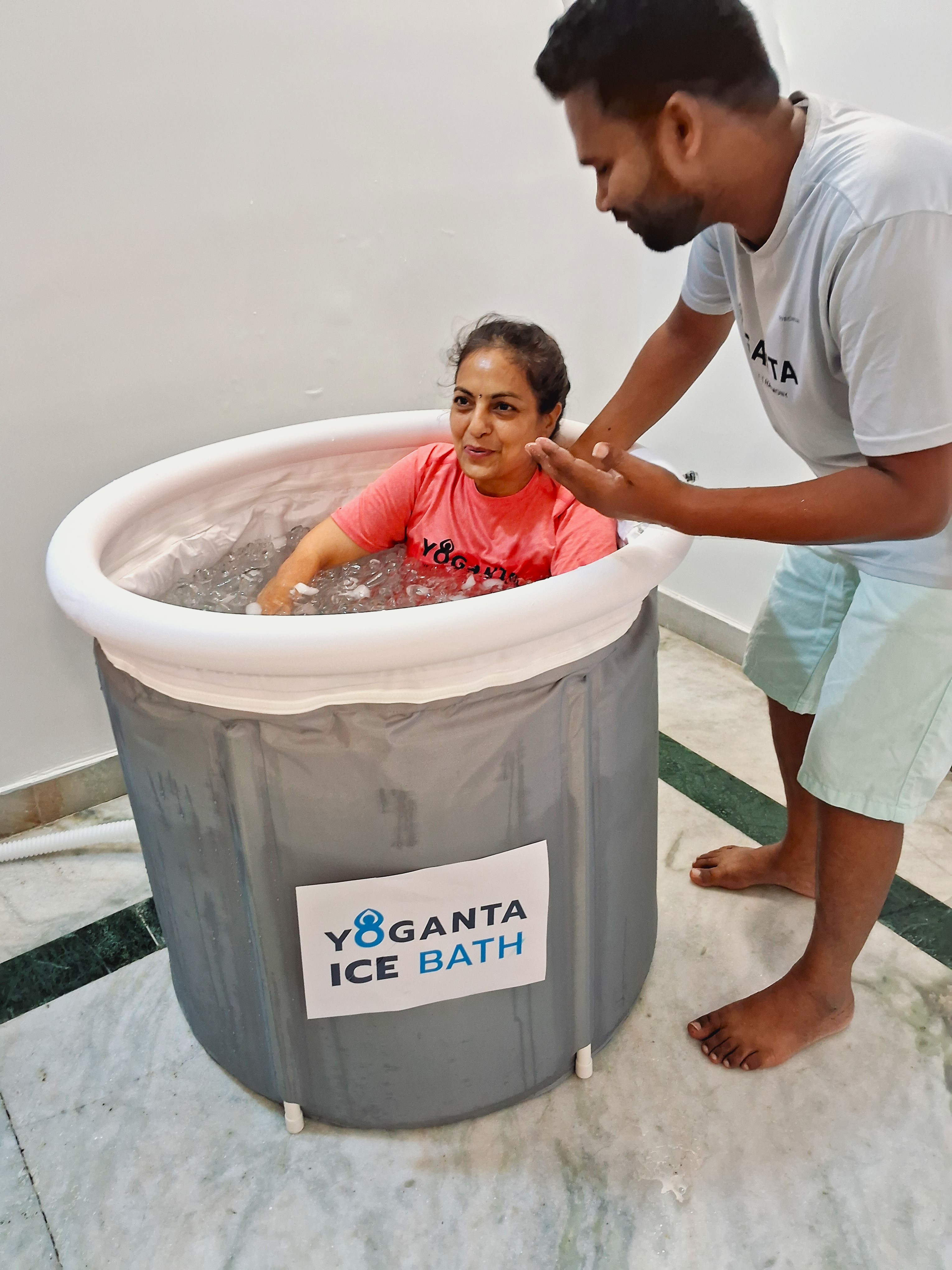Raushan Yoganta guiding a girl seated in a Yoganta Ice Bath tub during a Yoganta ice bath workshop.