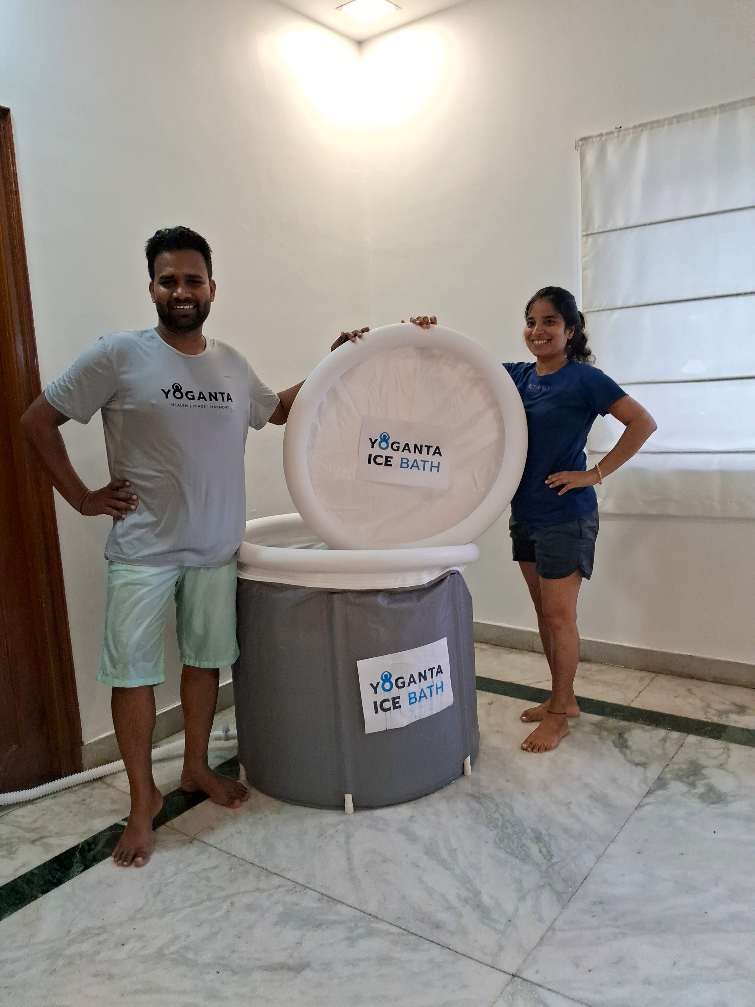 Raushan Yoganta and a woman standing beside a Yoganta Ice Bath tub with its lid raised during a Yoganta ice bath workshop.
